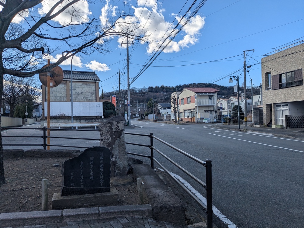 高崎の道。広々とした車のない車道のそばに、まばらに店や民家が並ぶ